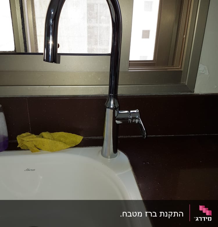 ברז מטבח כסוף מעל כיור לבן